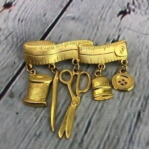 JJ Figural gold tone seamstress dangling charm brooch pin